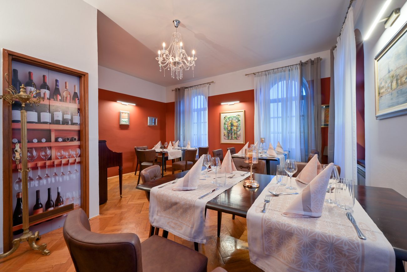 Salon s vitrinom za vino i postavljenim stolovima